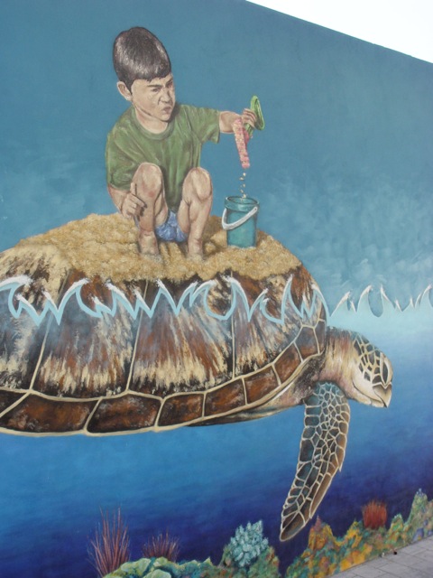Boy making a sandcastle on turtle-back