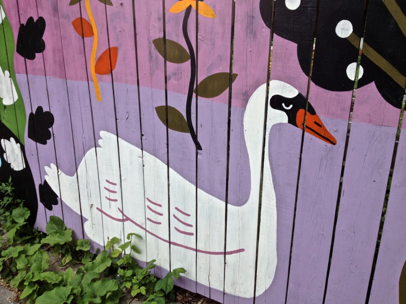 White Swan painted on pink and purple fence