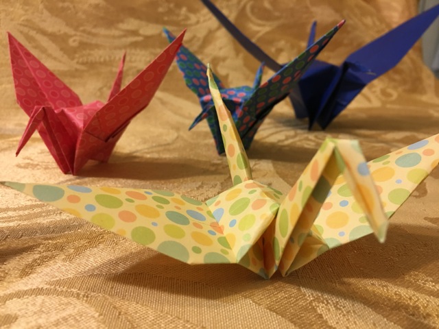 Four folded origami cranes